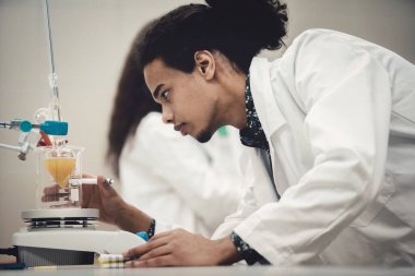 Laboratuvarda deney tüpüyle çalışan çok kültürlü bilim adamları.