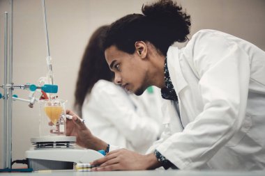 Laboratuvarda deney tüpüyle çalışan çok kültürlü bilim adamları.