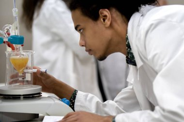 Laboratuvarda deney tüpüyle çalışan çok kültürlü bilim adamları.