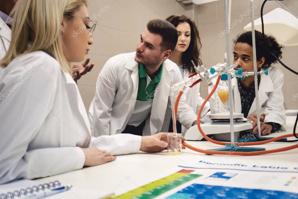 Multicurtural laboratory  scientist students working at lab with test tube