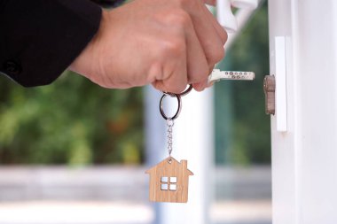 Ev sahibi yeni evin anahtarlarını açıyor.