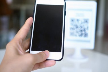 Eller, satın almada indirim almak için QR kodlarını taramak için telefonu kullanır..