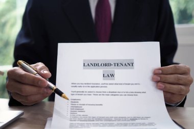 House salesman is showing Landlord-Tenant Law document. clipart