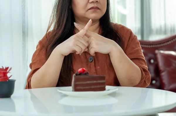 Fat women refuse to eat chocolate cakes. Intention to lose weight for good health and good shape