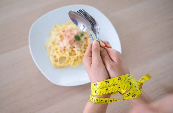 Tape measure around the arms of women. Stop eating trans fats, diet concept