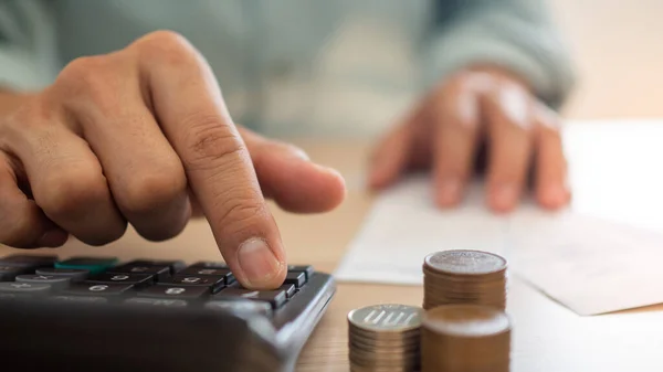 Hesap makinesi ve finansal planlama kullanan bir iş adamının yakın çekimi. Çeşitli ev faturalarının giderlerinin hesaplanması