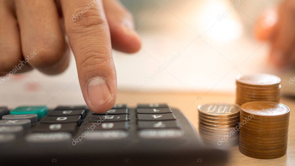 A close up of a business man using a calculator and financial planning. Calculation of expenses from various home bills