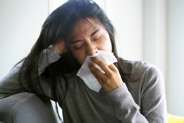 Asyalı kadınların yüksek ateşi ve burnu akıyor. hasta insanlar konsepti