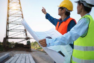 Mühendisler ve müteahhitler ev inşa planlarını tartışıyorlar..