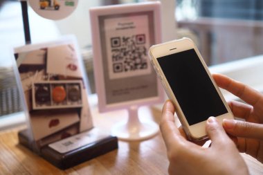 El, hükümet turizm programlarında indirim almak için QR kodunu taramak için telefonu kullanıyor..