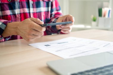 İş adamı cep telefonu uygulamalarını kullanarak faturaları ödemek için bir cep telefonu kullanıyor. Çevrimiçi ödeme ve alışveriş kavramları.
