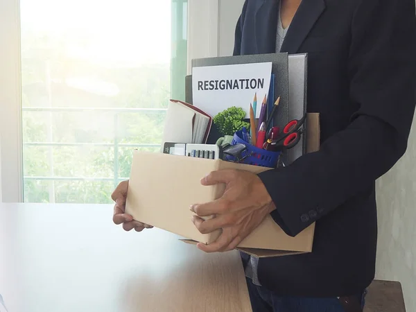 Businessmen hold boxes for personal belongings and resignation letters.