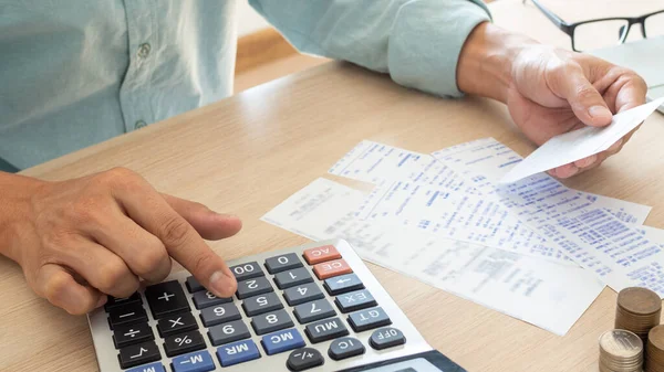 The butler is pressing the calculator calculate the various costs that must be paid by the bill. Many invoices held and placed on the table