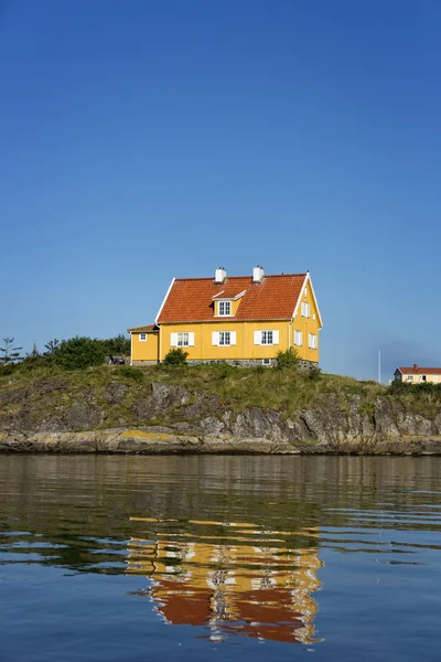 A yellow house on a rock. — Stock Photo, Image