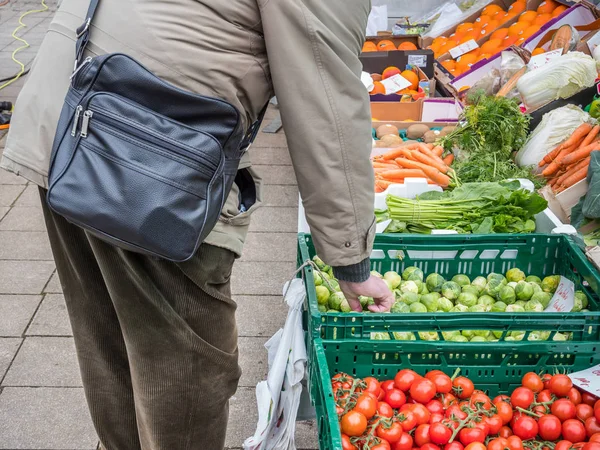 Пенсіонер купує овочі на ринку — стокове фото