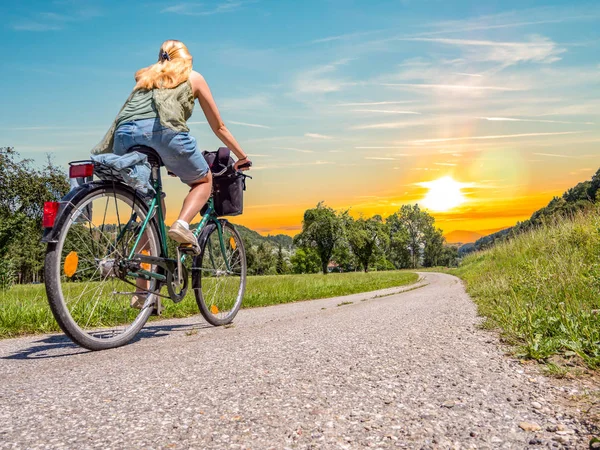 Genç Kadın Gün Batımında Bisiklet Sürüyor — Stok fotoğraf