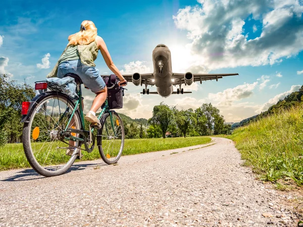 airplane on landing approach with woman on bicycle