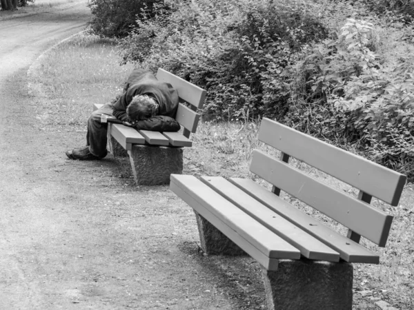 Man is sleeping on a park bench in Germany