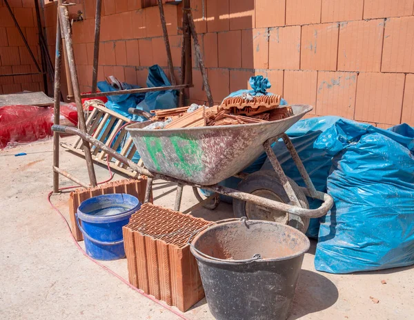 Shell of a family house with  wheelbarrow and — Stock Photo, Image