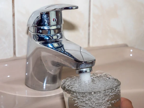 Beba agua del grifo con un vaso — Foto de Stock