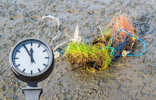 Reloj con residuos de plástico en la playa —  Fotos de Stock