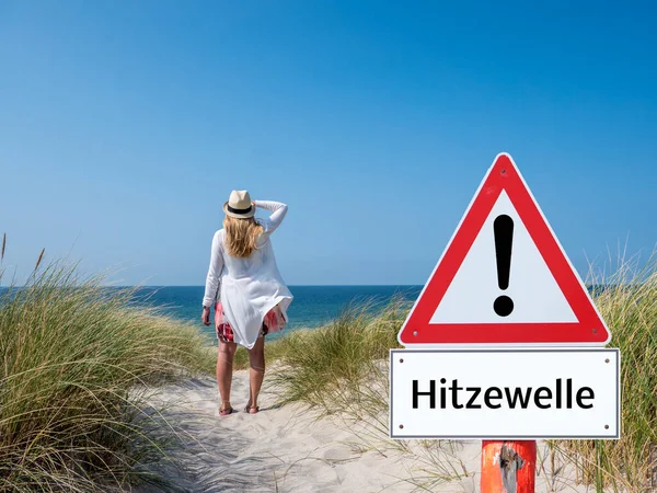 Немецкая женщина с предупреждающим знаком тепловой волны — стоковое фото