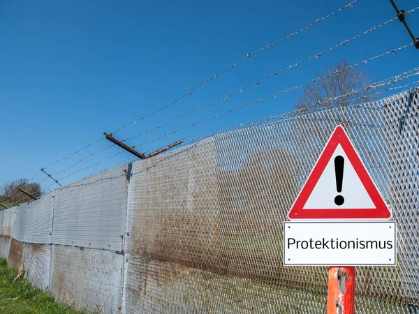 Grenshek met waarschuwingsbord protectionisme in het Duits — Stockfoto