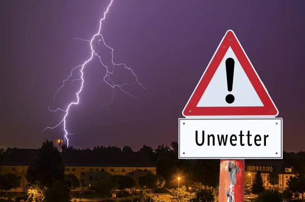 Blesková bouře ve večerních hodinách s městskými světly německá výstražná značka — Stock fotografie