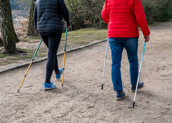 Dos mujeres haciendo nordic walking en primavera —  Fotos de Stock