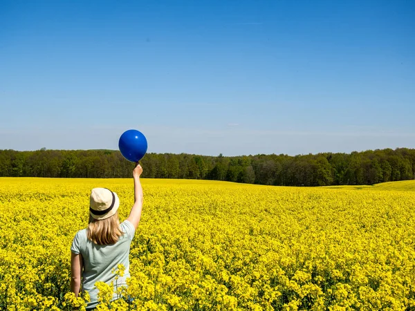 Donna con palloncino blu nel campo stupro — Foto Stock