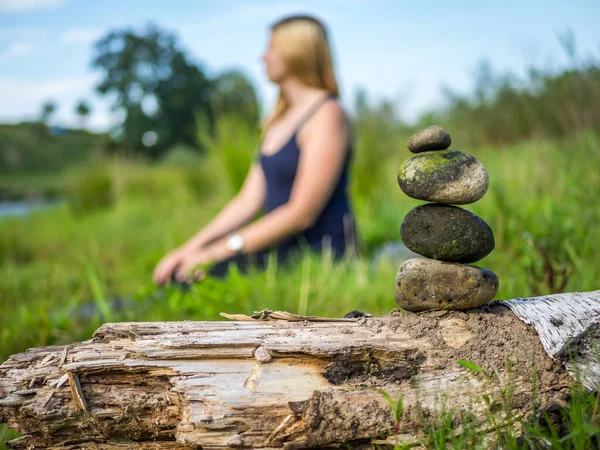 Mujer sentada en la naturaleza y meditando con piedras —  Fotos de Stock
