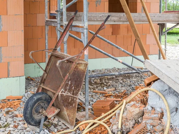 Old rusty wheelbarrow while building a house — Stock Photo, Image