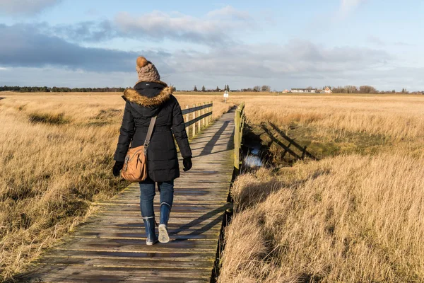 Woman running in winter on the beach path at the North Sea — Stockfoto