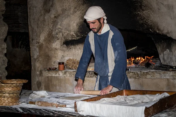 Un homme vêtu de vêtements d'époque roule la pâte dans le village de Nazareth — Photo