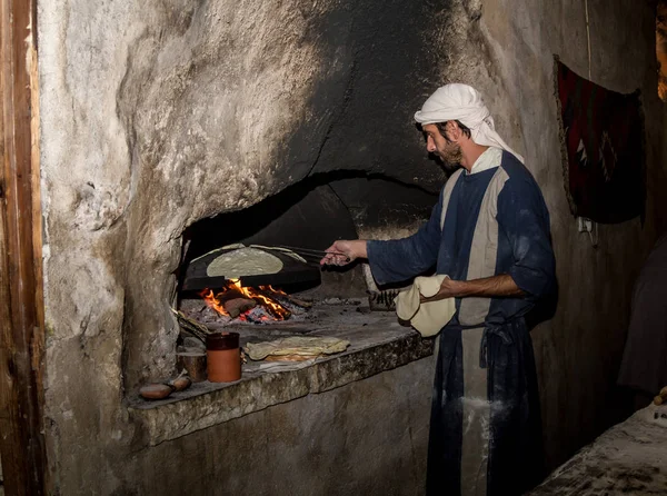 Άνδρας με περίοδο ρούχα ψήνει ψωμί, χωριό της Ναζαρέτ — Φωτογραφία Αρχείου