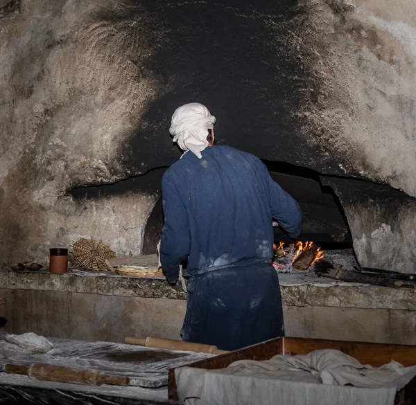 Άνδρας με περίοδο ρούχα ψήνει ψωμί, χωριό της Ναζαρέτ — Φωτογραφία Αρχείου