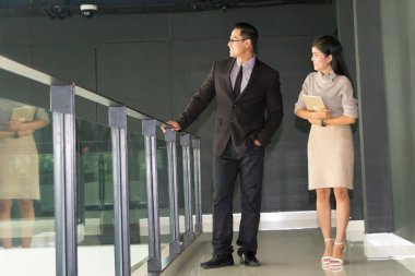 Yöneticiler ve sekreterler kapalı koridorlarda yürüyorlar.