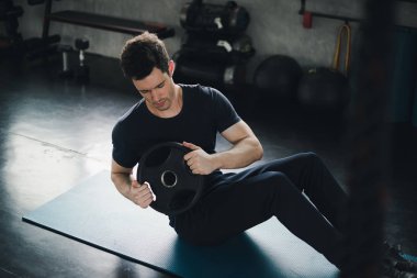 Young man caucasian was exercising by the use weight plate on yo