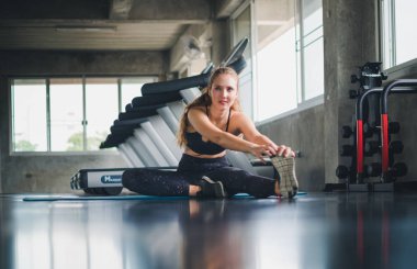 Güzel bir sporcu bir takım elbise giydi. Bir kas üzerinde gerinme