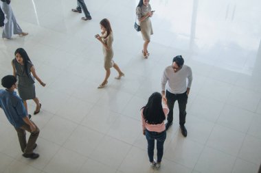 Asyalı ofis çalışanları ofiste el sıkışarak birbirlerini selamlıyorlar.