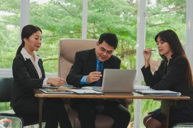 Yöneticiler ve çalışanlar iş yerinde iş konuşuyorlar.