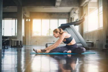 Güzel bir sporcu bir takım elbise giydi. Bir kas üzerinde gerinme