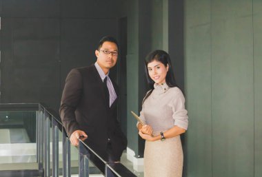 Yöneticiler ve sekreterler kapalı koridorlarda yürüyorlar.