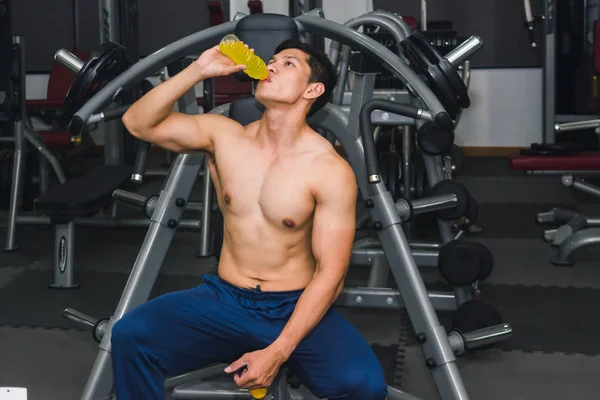 Asian man has muscle exercise in the gym.And he are tired, so dr