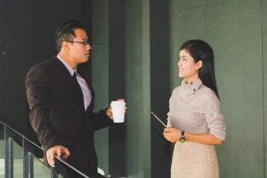 Yöneticiler ve sekreterler kapalı koridorlarda yürüyorlar.