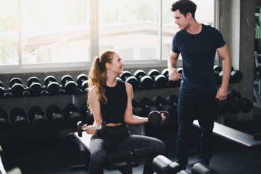 Güzel bir kadın egzersiz ve spor yapıyor. Antrenör veriyor.