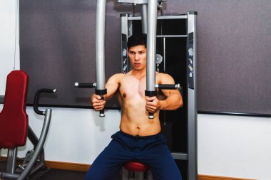 Asyalı kaslı adamlar spor salonunda ağırlık kaldırıyor..