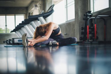Güzel bir sporcu bir takım elbise giydi. Bir kas üzerinde gerinme