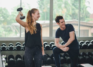 Güzel bir kadın egzersiz ve spor yapıyor. Antrenör veriyor.