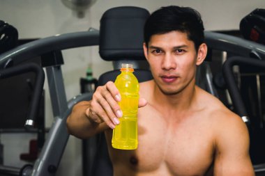 Asyalı adamın spor salonunda kas egzersizi var ve çok yorgun.